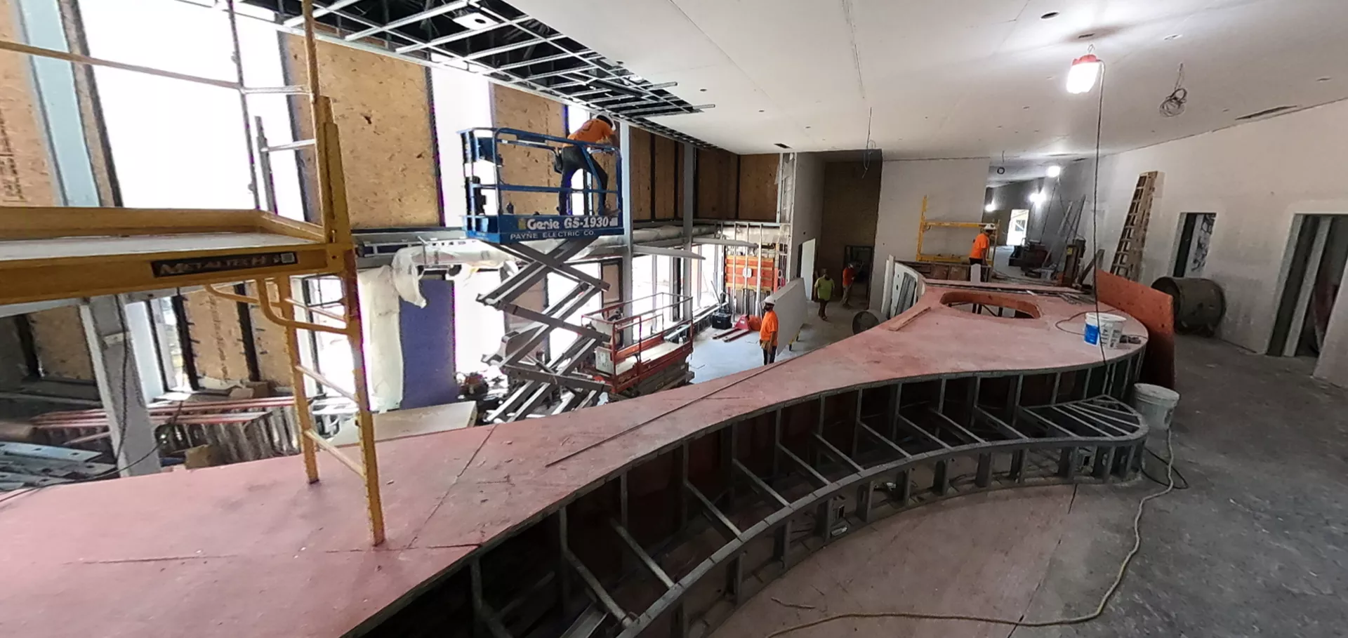 Alternate angle of construction working performing ceiling work and windows