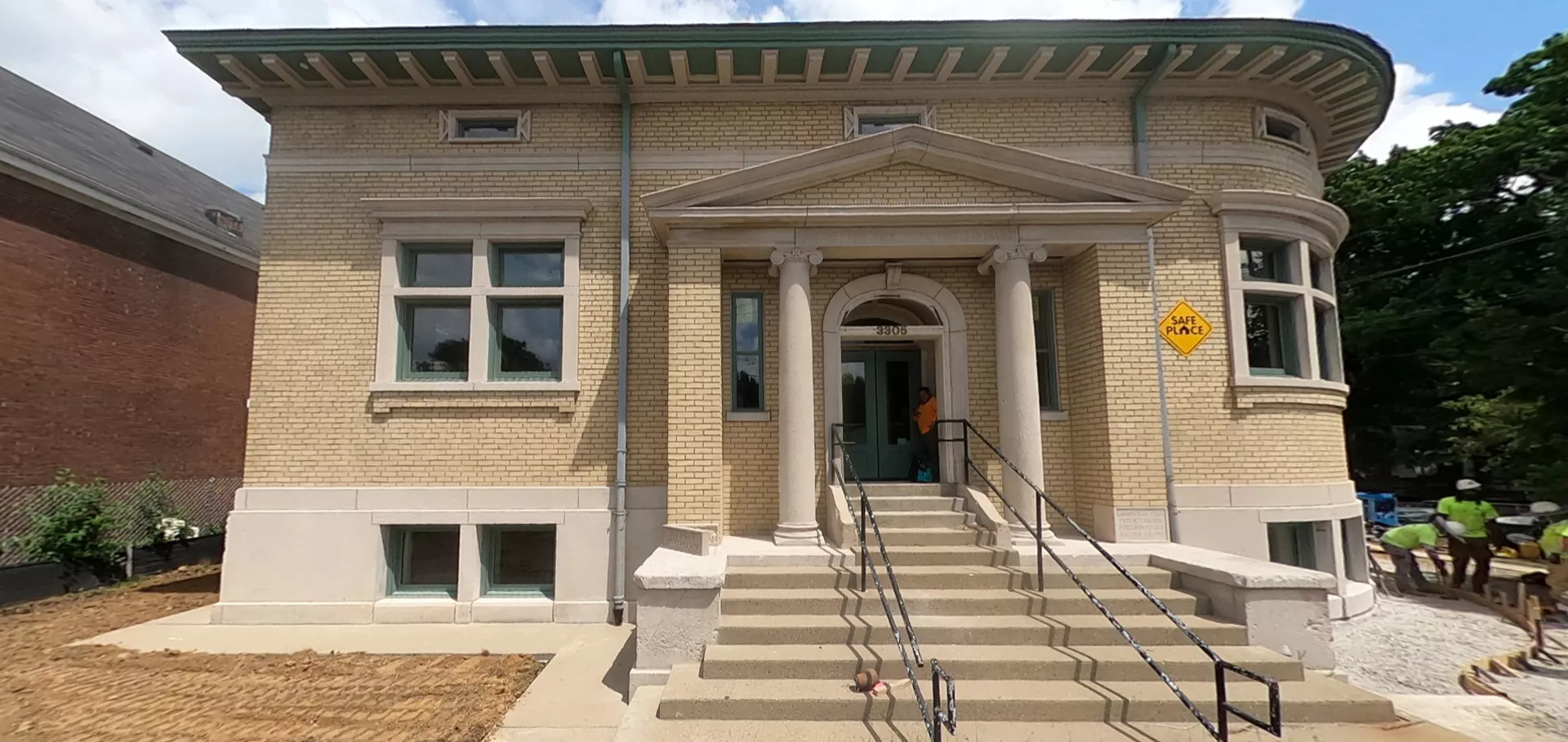 External view of the original building with construction workers on the side