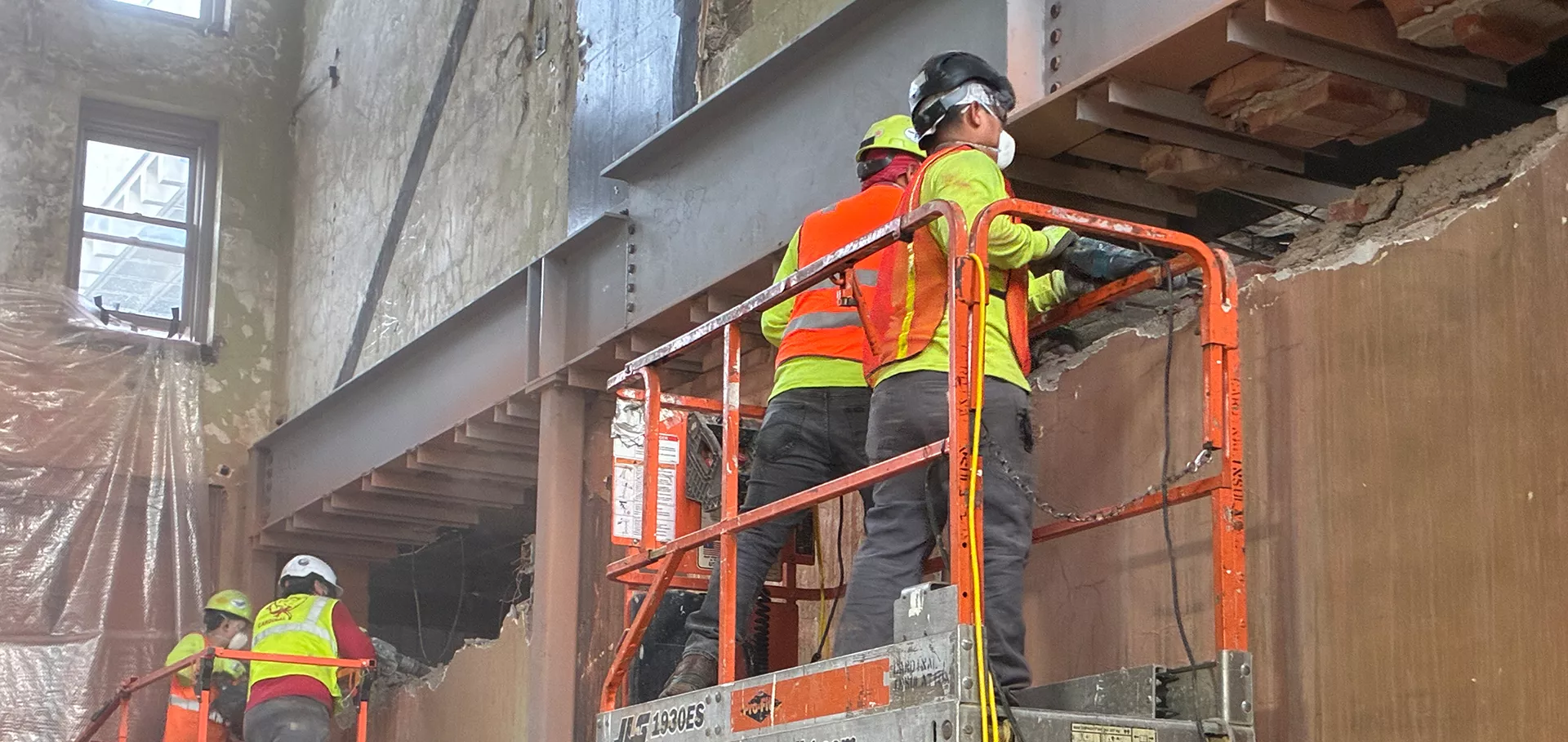 Construction workers working on metal beam