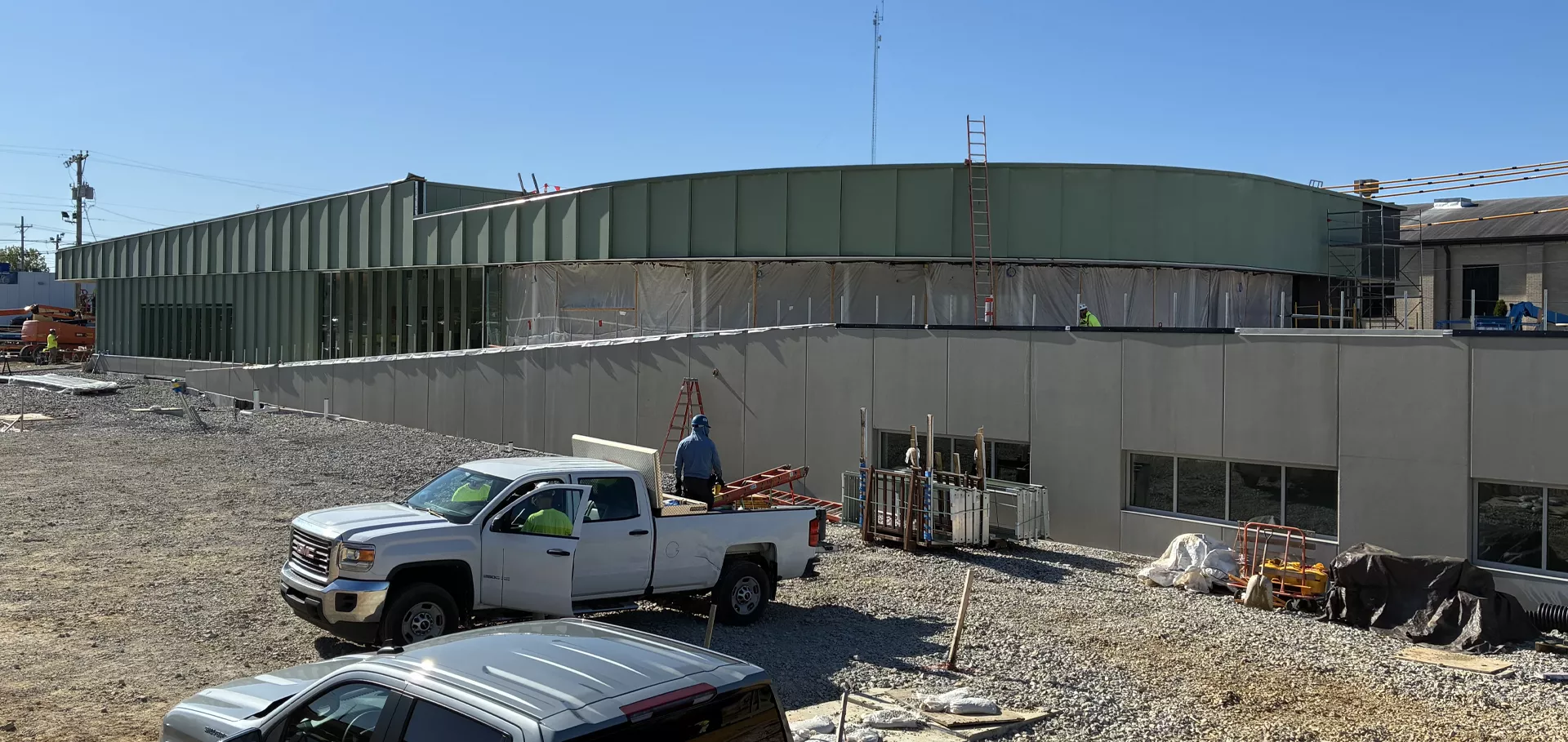 Construction workers working on the external wall of Fern Creek
